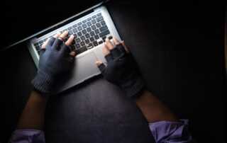 person in black long sleeve shirt using macbook pro