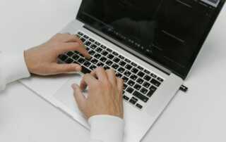 Free Hands on a Laptop Keyboard Stock Photo